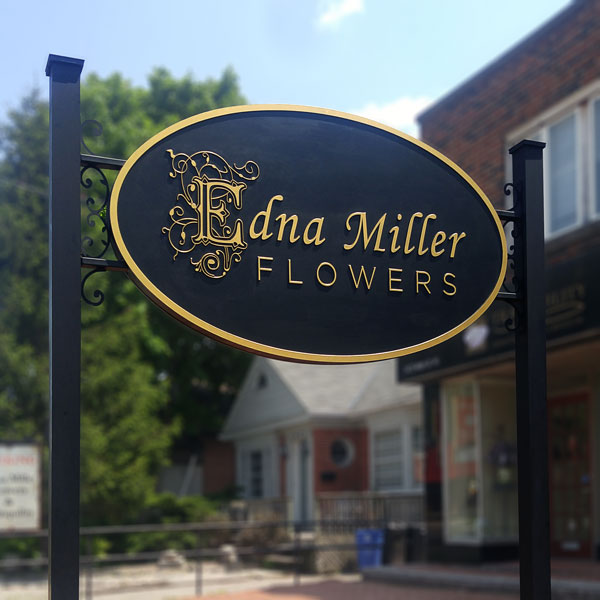 Carved MDF sign, black backgrond with gold text and order, installed between 2 posts