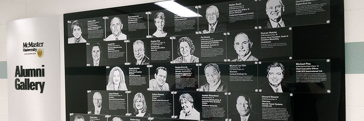 Black & silver display wall with photos of distinguished alumni etched in