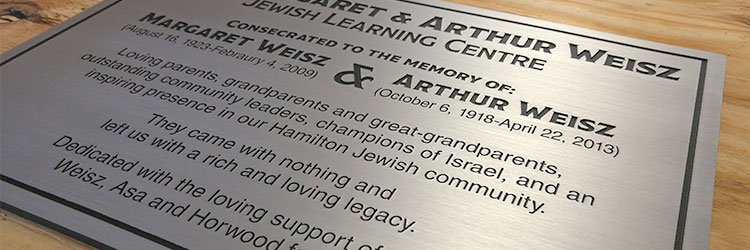 Brushed aluminum metal plaque with black text engraved