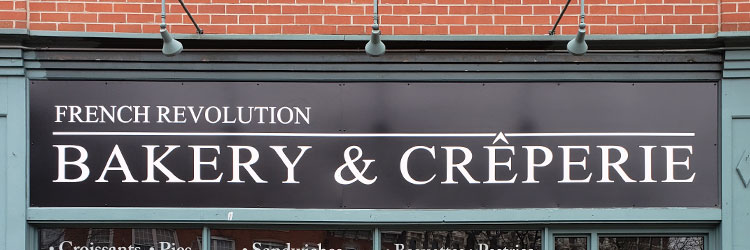 Black storefront sign with white letters applied
